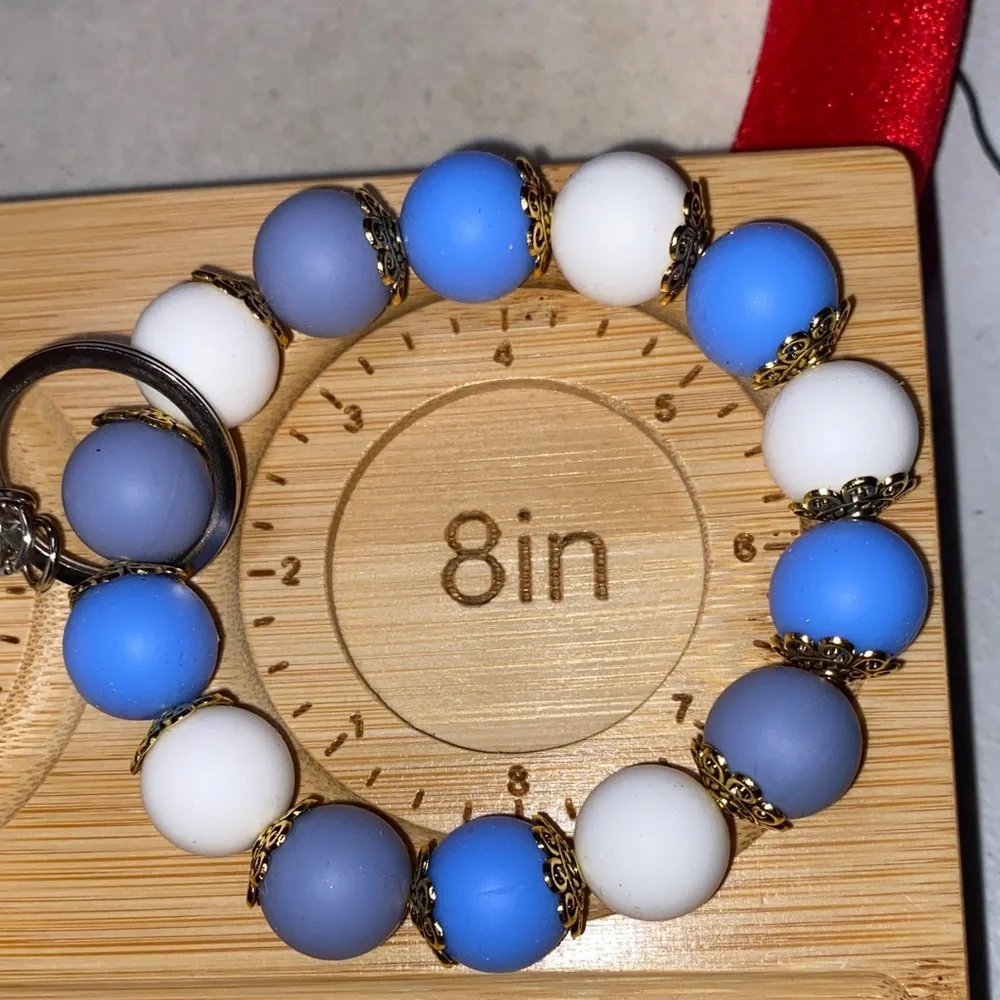 Blue and white bracelet keychain with white pom-pom
